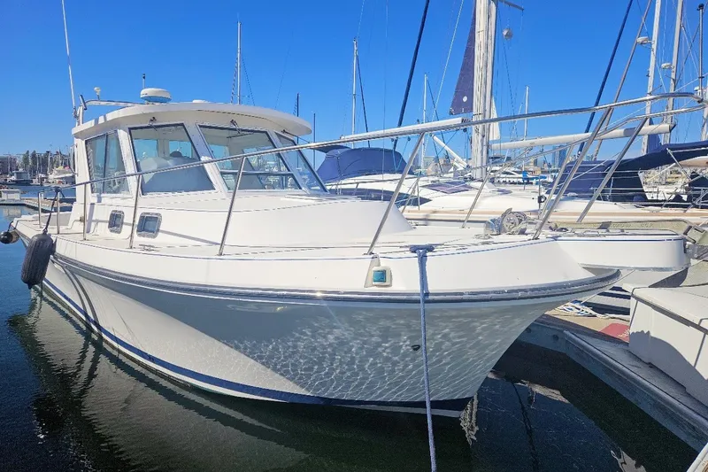 Slide: The Image of 2000 Albin 31 Tournament Express boat docked in a marina under clear blue skies. - 0