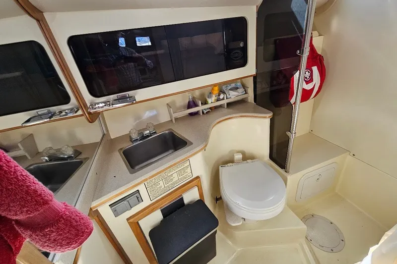 Slide: The Image of 2000 Albin 31 Tournament Express bathroom with sink, toilet, and storage shelves. - 23