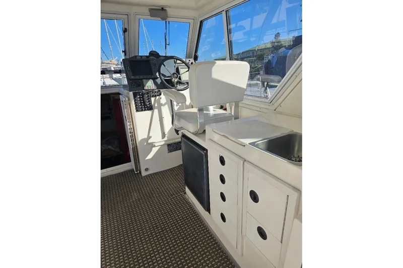 Slide: The Image of Interior of 2000 Albin 31 Tournament Express boat with helm, sink, and storage cabinets. - 11