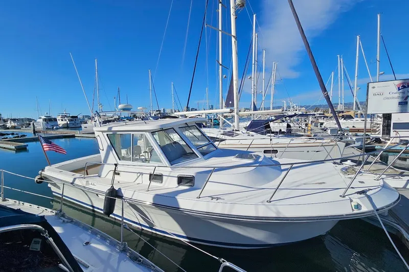 Slide: The Image of 2000 Albin 31 Tournament Express boat docked in a marina under clear blue skies. - 3