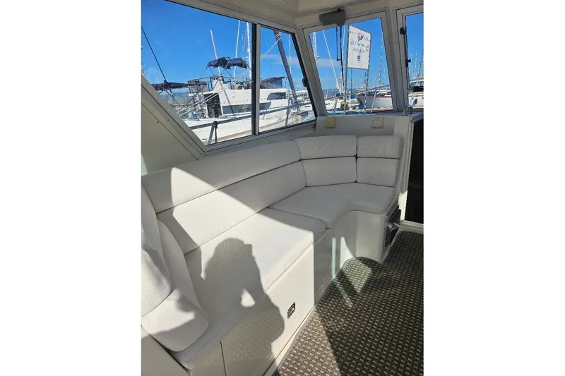 Slide: The Image of Interior of 2000 Albin 31 Tournament Express with white seating and marina view. - 24