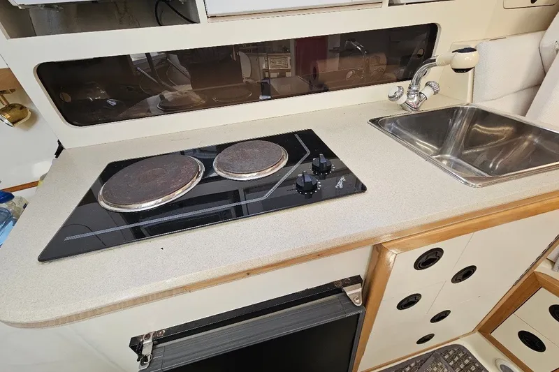 Slide: The Image of Compact kitchen area in a 2000 Albin 31 Tournament Express boat with stove and sink. - 21