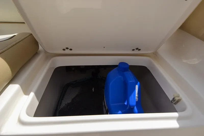 Slide: The Image of An open storage compartment on a boat with a blue jug and a net. - 15