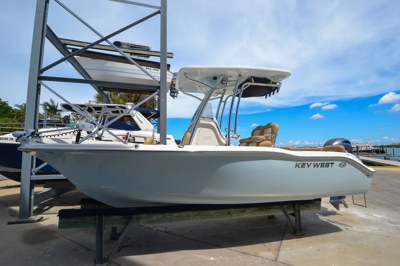 Slide: The Image of A 2018 Key West 219 FS boat is on a dock with a blue sky in the background. - 27
