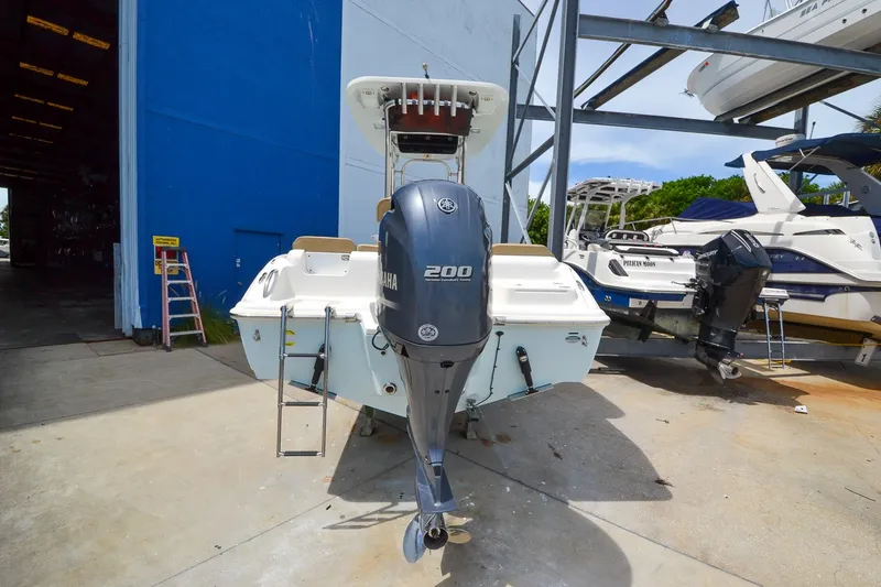Slide: The Image of A 2018 Key West 219 FS boat with a 200 HP outboard motor, parked in a boatyard. - 25