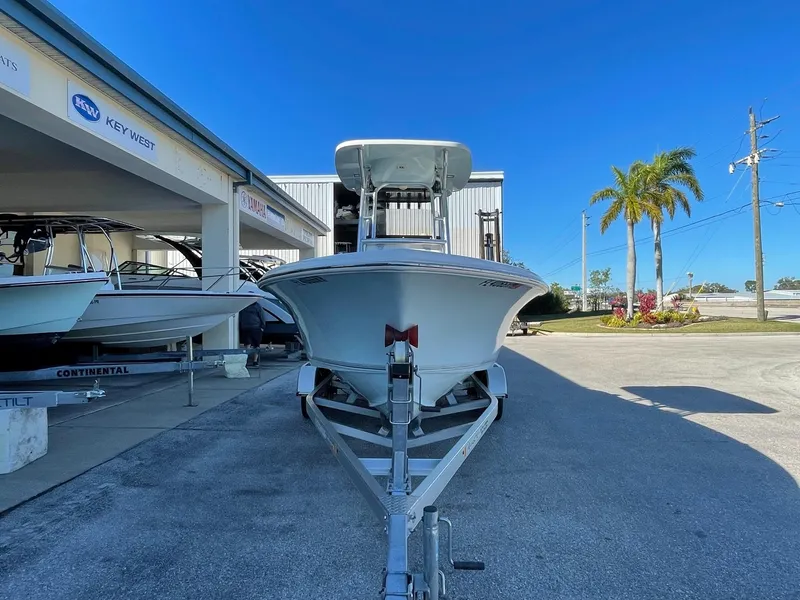 Slide: The Image of A 2018 Key West 219 FS boat on a trailer in front of a building with palm trees. - 32
