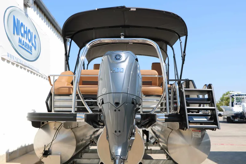 Slide: The Image of 2027 Bennington 23 MSB with Yamaha outboard motor, on a trailer, in front of a building. - 16