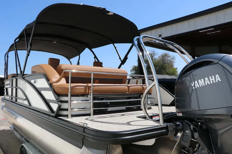 Slide: The Image of The image shows a Bennington 23 MSB pontoon boat with a Yamaha engine, parked in a lot. - 17