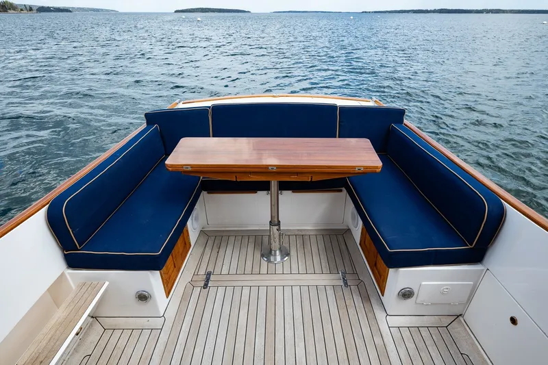 Slide: The Image of CH Marine 38 Runabout 2000 boat interior with blue seating and wooden table on open water. - 17