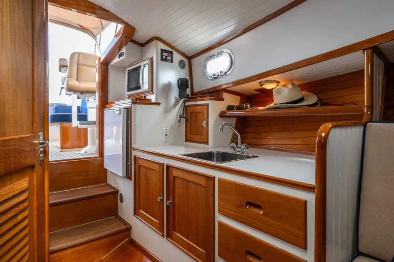 Slide: The Image of Interior of 2000 CH Marine 38 Runabout with kitchenette, wooden cabinets, and nautical decor. - 28