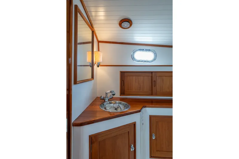 Slide: The Image of Elegant wooden interior of 2000 CH Marine 38 Runabout, featuring sink and storage cabinets. - 32