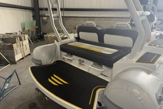 Slide: The Image of 2025 Highfield Velox 420 boat interior with seating and storage in a warehouse setting. - 5