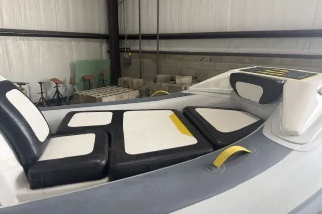 Slide: The Image of 2025 Highfield Velox 420 boat interior with cushioned seating in a warehouse setting. - 8