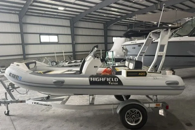 Slide: The Image of 2025 Highfield Velox 420 inflatable boat on trailer in indoor storage facility. - 2