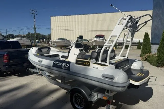 Slide: The Image of 2025 Highfield Velox 420 boat on trailer, parked outdoors in a sunny marina. - 12