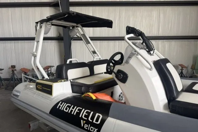 Slide: The Image of 2025 Highfield Velox 420 inflatable boat with sleek design in a storage facility. - 7