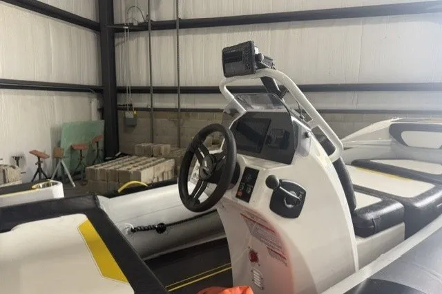 Slide: The Image of 2025 Highfield Velox 420 boat interior with steering console in a storage facility. - 6