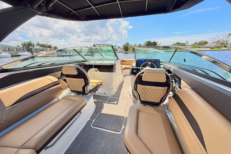 Slide: The Image of 2023 Sea Ray SLX 260 Outboard interior with luxurious seating and modern dashboard on a sunny day. - 9