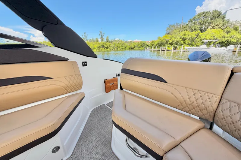 Slide: The Image of 2023 Sea Ray SLX 260 Outboard interior with tan seating, scenic water view. - 10