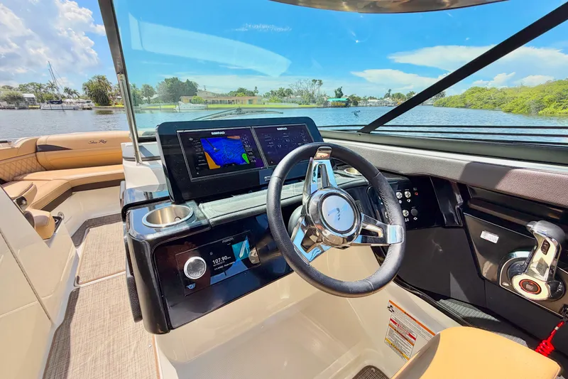 Slide: The Image of 2023 Sea Ray SLX 260 Outboard helm with modern controls and scenic water view. - 20