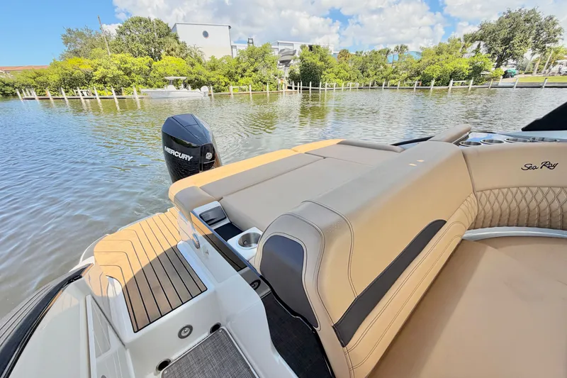 Slide: The Image of 2023 Sea Ray SLX 260 Outboard boat with tan seating and Mercury engine on a calm lake. - 6