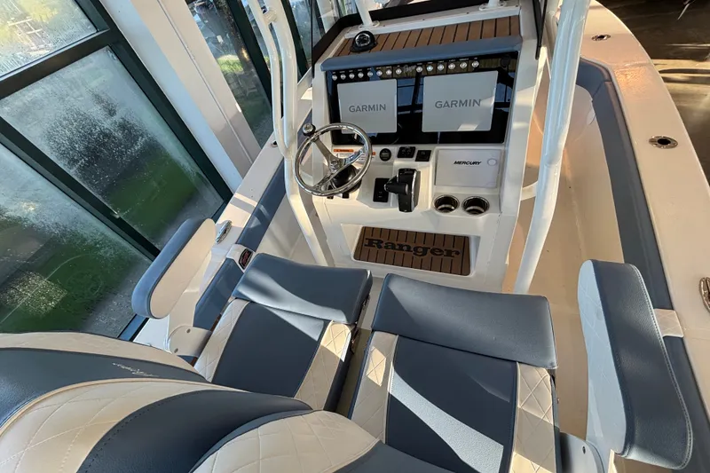Slide: The Image of 2025 Ranger 2600 Bay boat interior with dual Garmin displays and comfortable seating. - 7