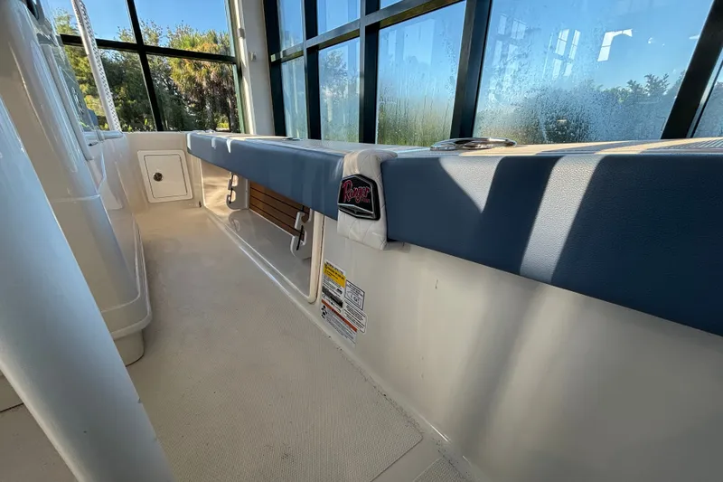 Slide: The Image of 2025 Ranger 2600 Bay boat interior with cushioned seating and sunlight through windows. - 10
