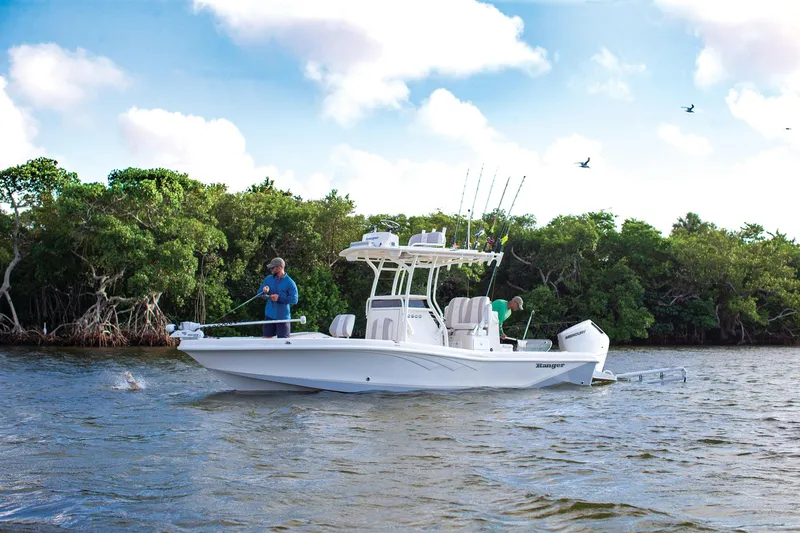 Slide: The Image of Manufacturer Provided Image: 2025 Ranger 2600 Bay boat on water, two people fishing, lush greenery in background. - 13