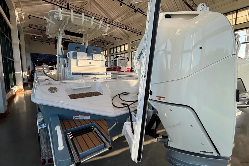 Slide: The Image of 2025 Ranger 2600 Bay boat displayed indoors with powerful engine and sleek design. - 3