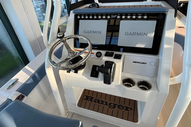 Slide: The Image of 2025 Ranger 2600 Bay boat dashboard with dual Garmin displays and Mercury controls. - 6