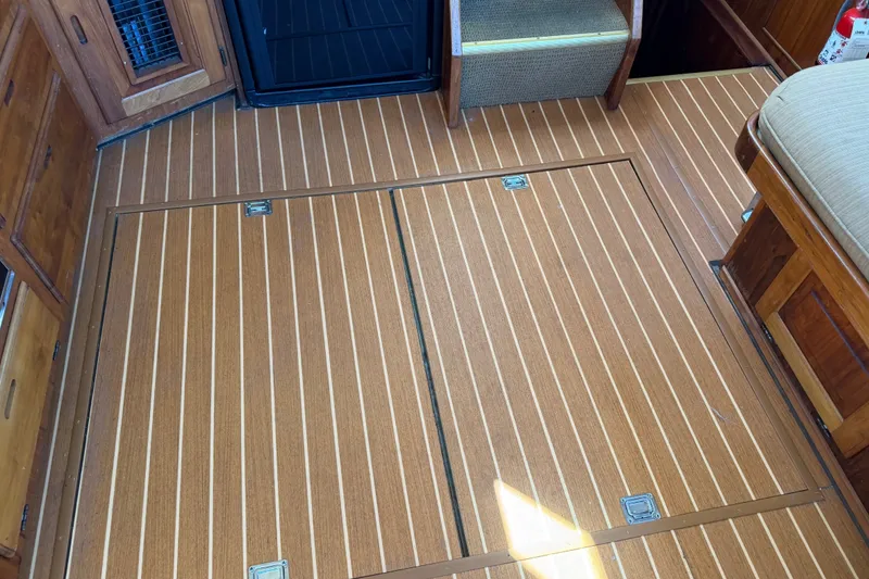 Slide: The Image of 1984 Californian 43 Cockpit MY interior with wood panel flooring and storage compartments. - 52