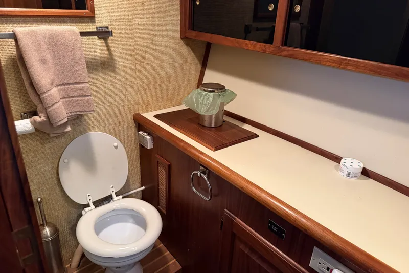 Slide: The Image of 1984 Californian 43 Cockpit MY bathroom with toilet, countertop, and wooden cabinetry. - 32
