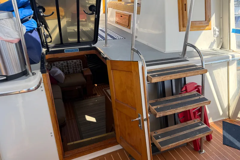 Slide: The Image of Interior view of 1984 Californian 43 Cockpit MY yacht with wooden stairs and seating area. - 16