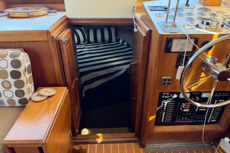 Slide: The Image of 1984 Californian 43 Cockpit MY interior with striped bedding and wooden helm controls. - 28