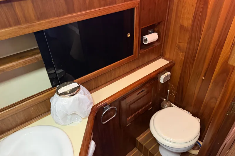 Slide: The Image of Das Bild zeigt ein Badezimmer mit Holzwänden, einer Toilette und einem Waschbecken. Ein Regal ist sichtbar. - 48