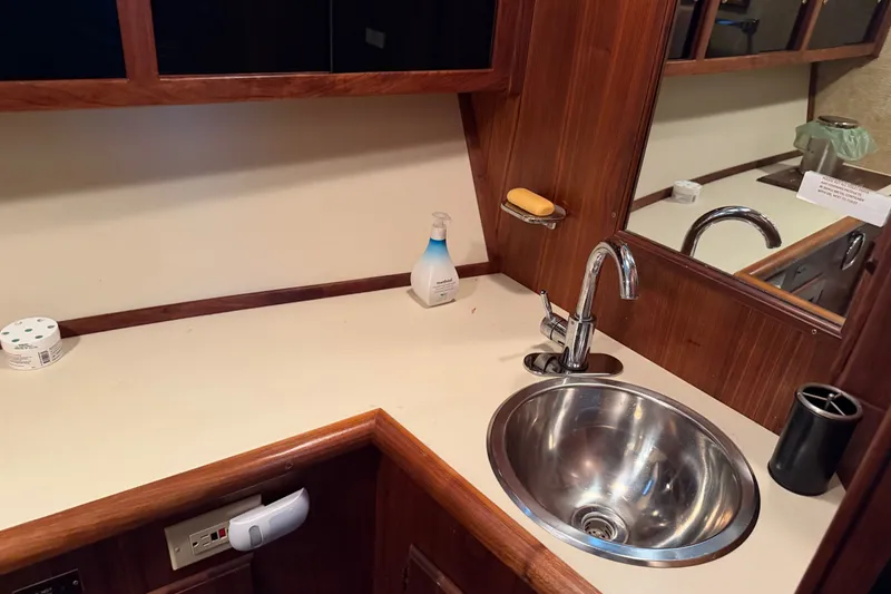 Slide: The Image of 1984 Californian 43 Cockpit MY yacht bathroom with sink, wooden cabinetry, and countertop accessories. - 33
