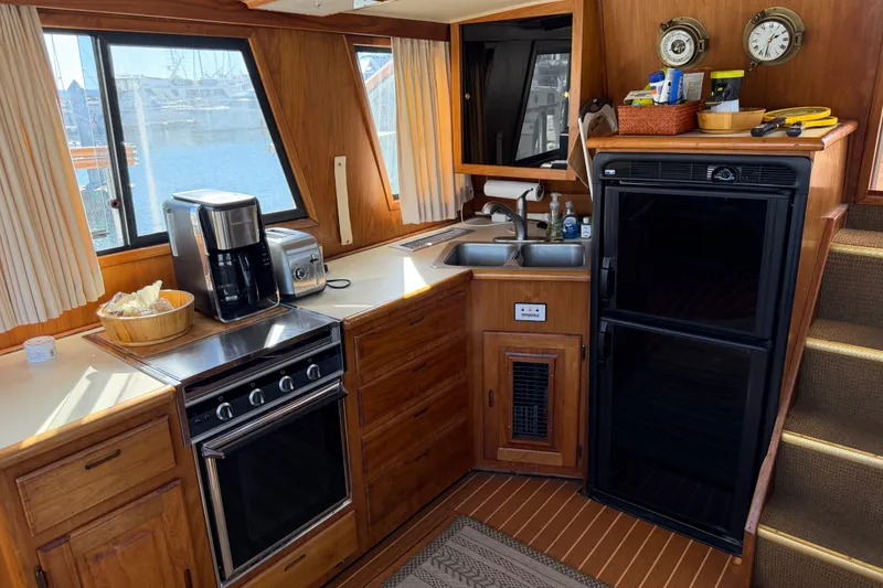 Slide: The Image of Cozy kitchen in 1984 Californian 43 Cockpit MY yacht with wood cabinetry and appliances. - 20