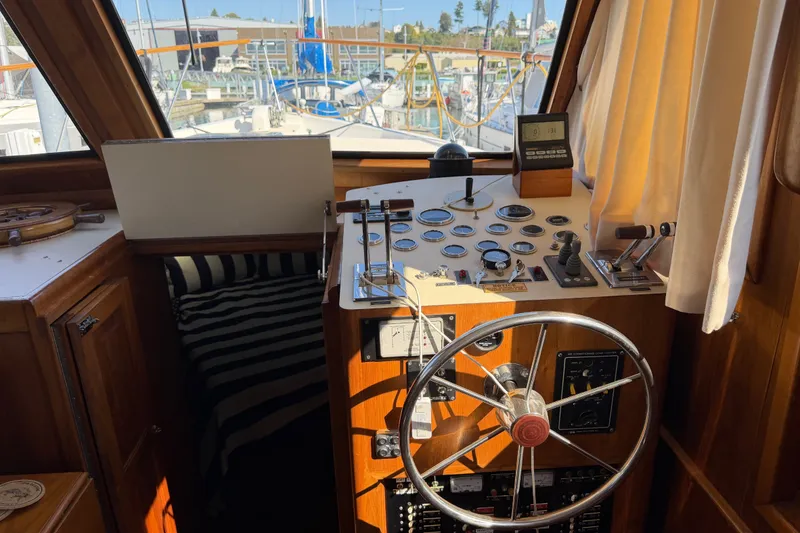 Slide: The Image of 1984 Californian 43 Cockpit MY helm with steering wheel, gauges, and marina view. - 25