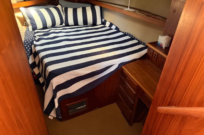 Slide: The Image of Cozy cabin interior of 1984 Californian 43 Cockpit MY with striped bedding. - 29