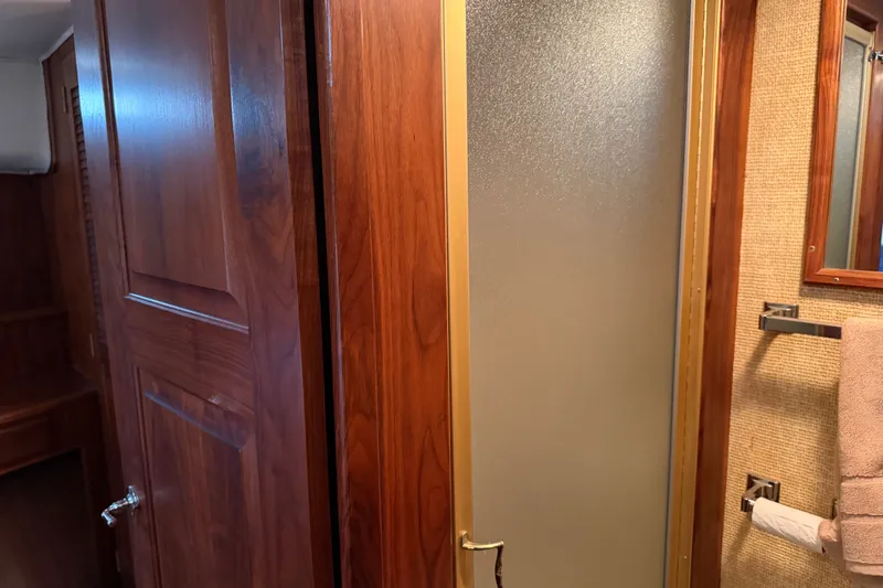Slide: The Image of Interior of 1984 Californian 43 Cockpit MY yacht, featuring wooden cabinetry and frosted glass shower door. - 34