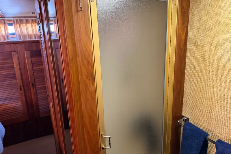 Slide: The Image of Interior of 1984 Californian 43 Cockpit MY yacht with wooden cabinetry and frosted shower door. - 49