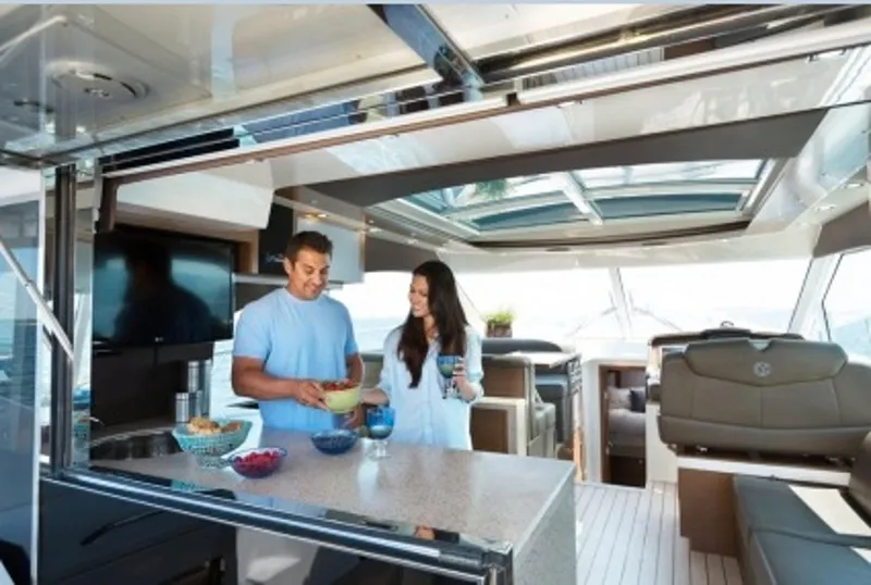 Slide: The Image of Manufacturer Provided Image: Couple enjoying the kitchen area inside a 2014 Cruisers Yachts 45 Cantius. - 9