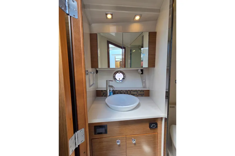 Slide: The Image of Luxurious bathroom in 2014 Cruisers Yachts 45 Cantius, featuring modern sink and wood cabinetry. - 25