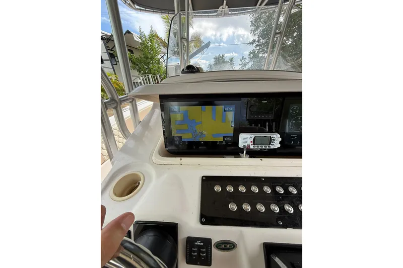 Slide: The Image of 2004 Grady-White Canyon 306 boat dashboard with navigation screen and controls. - 27