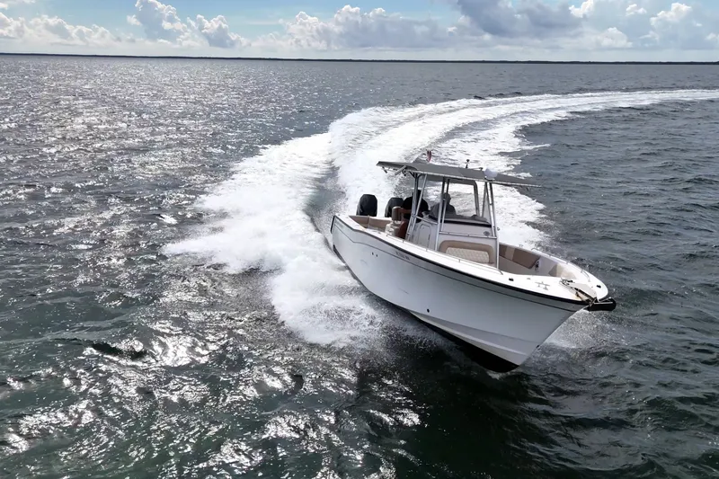 Slide: The Image of A 2004 Grady-White Canyon 306 boat cruising on open water under a partly cloudy sky. - 0
