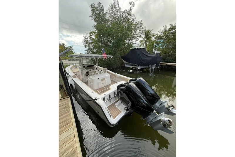 Slide: The Image of 2004 Grady-White Canyon 306 boat docked, featuring dual outboard motors and spacious deck. - 9