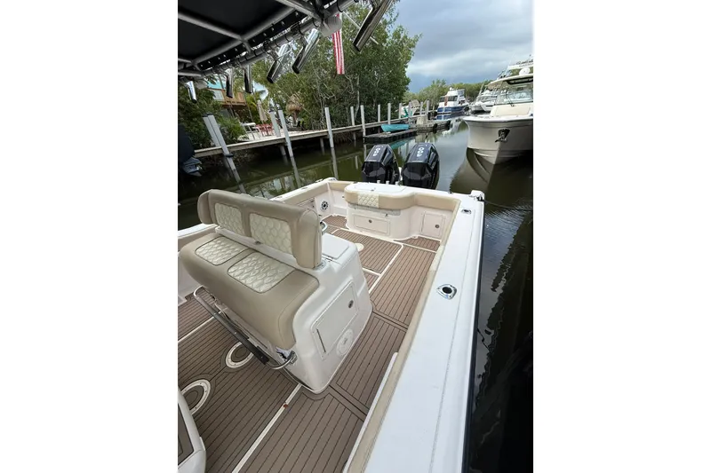 Slide: The Image of 2004 Grady-White Canyon 306 boat interior with seating and twin engines at dock. - 16