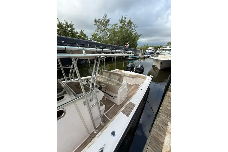 Slide: The Image of 2004 Grady-White Canyon 306 boat docked, featuring spacious deck and dual outboard motors. - 15