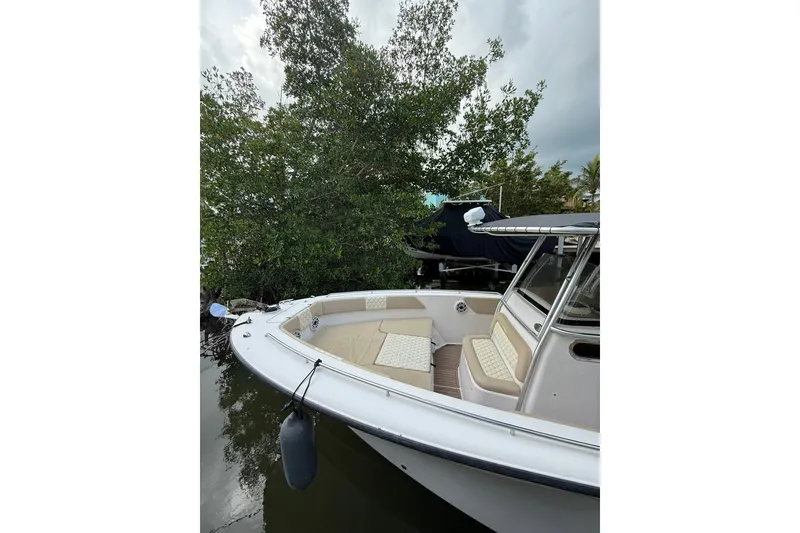 Slide: The Image of 2004 Grady-White Canyon 306 boat docked near lush greenery. - 13