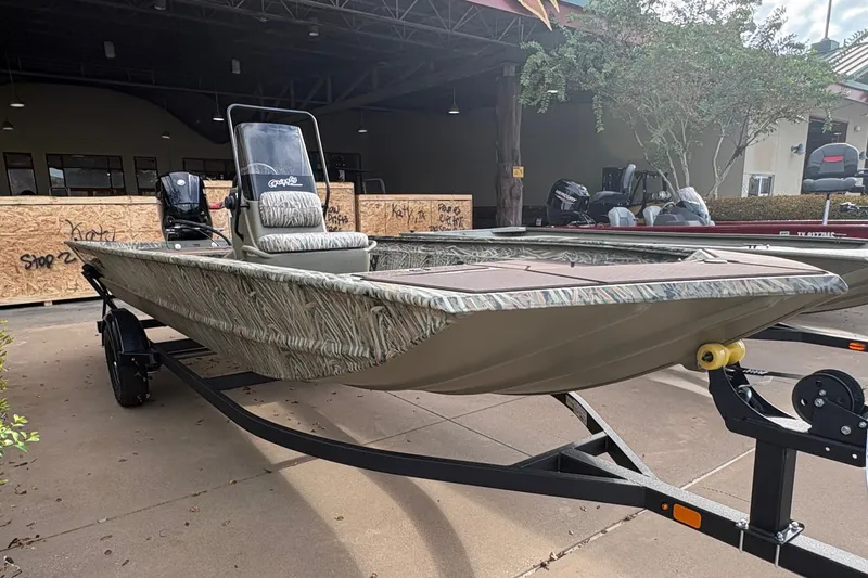 The Image of 2027 Tracker Grizzly 1860 CC in a showroom, featuring camouflage pattern and trailer. - 0